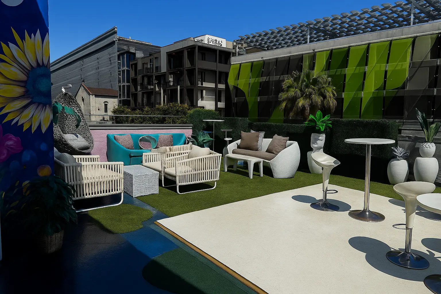 The rooftop lounge in daylight with the mural wall and hanging chair