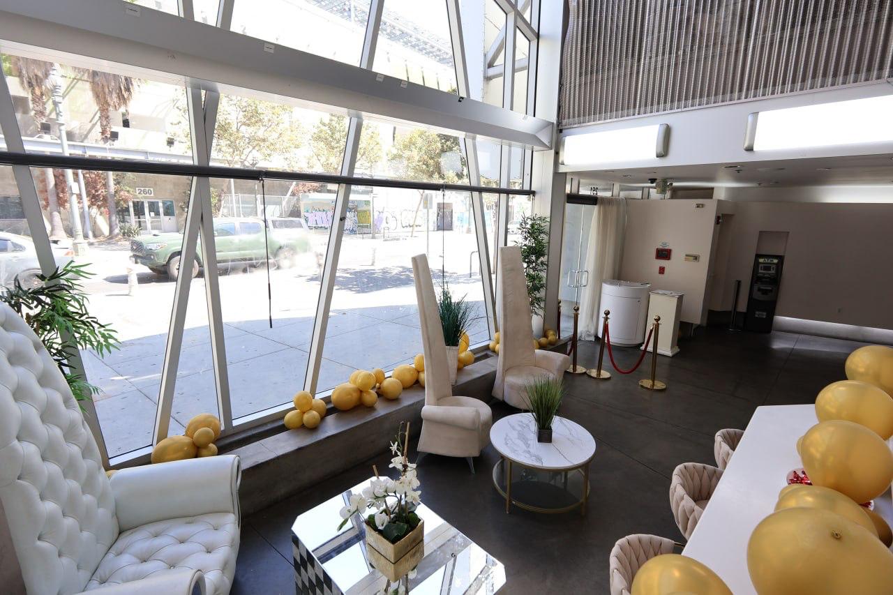 The glass atrium dressed with gold balloons and high-backed chairs