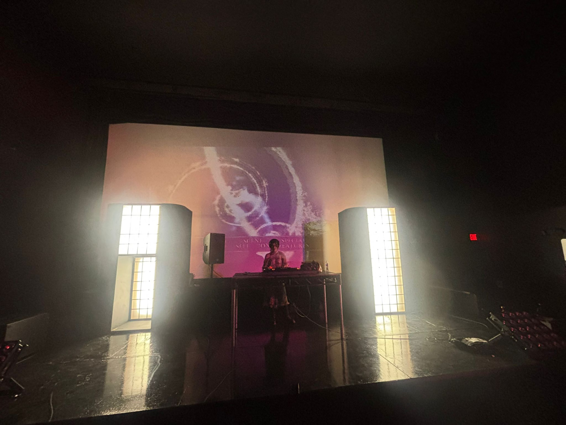 A performer silhouetted against the glowing theater screen