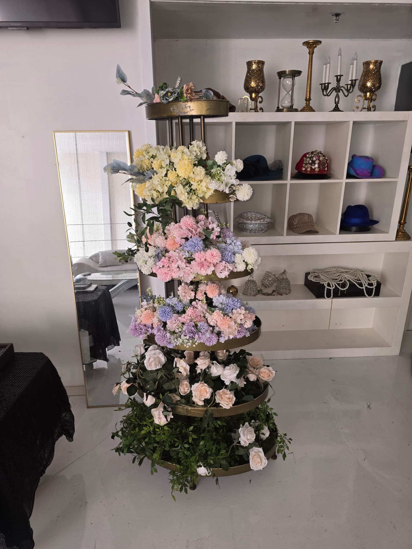 A tiered floral tower in the styling suite beside the full-length mirror