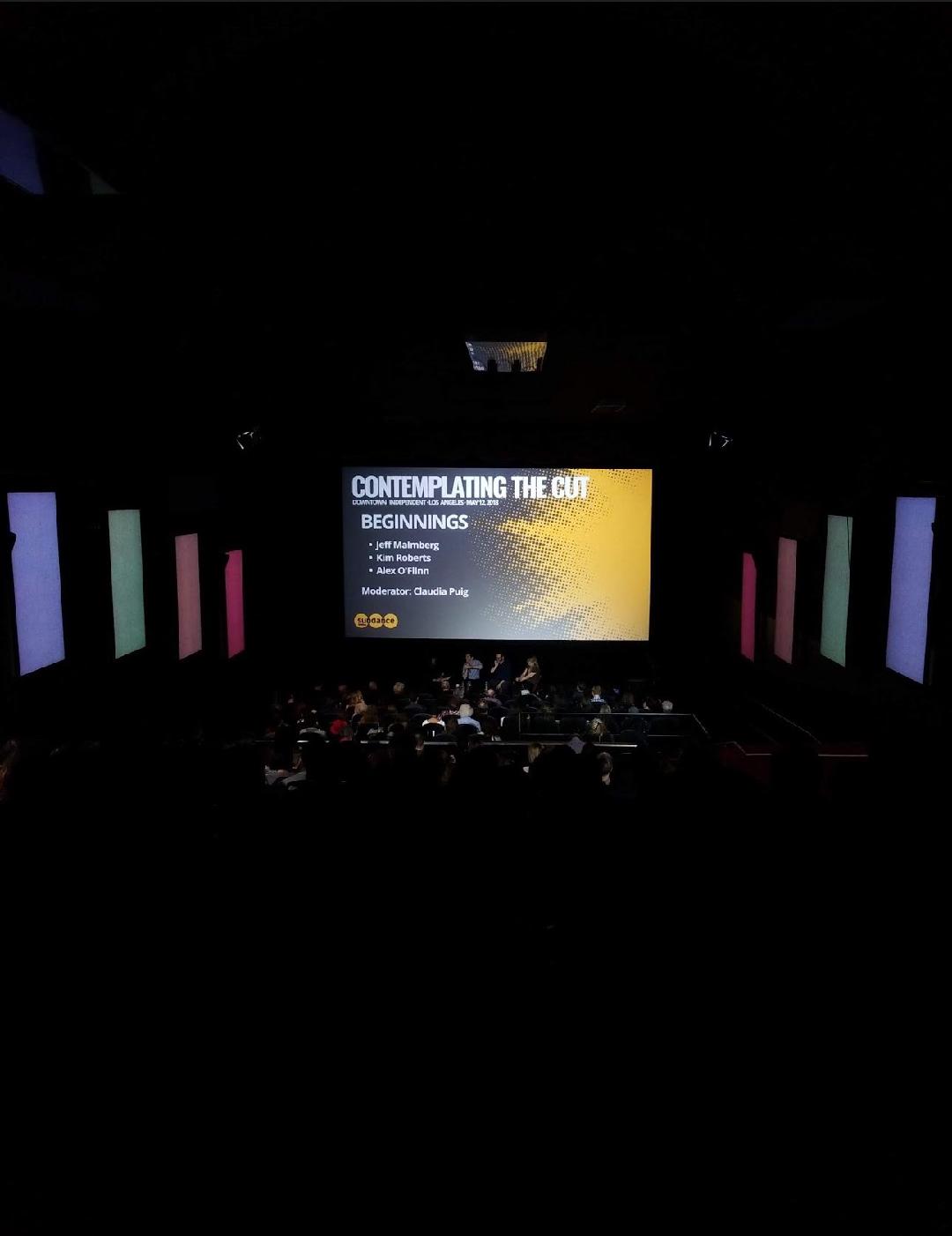 A festival panel on stage in the darkened theater house