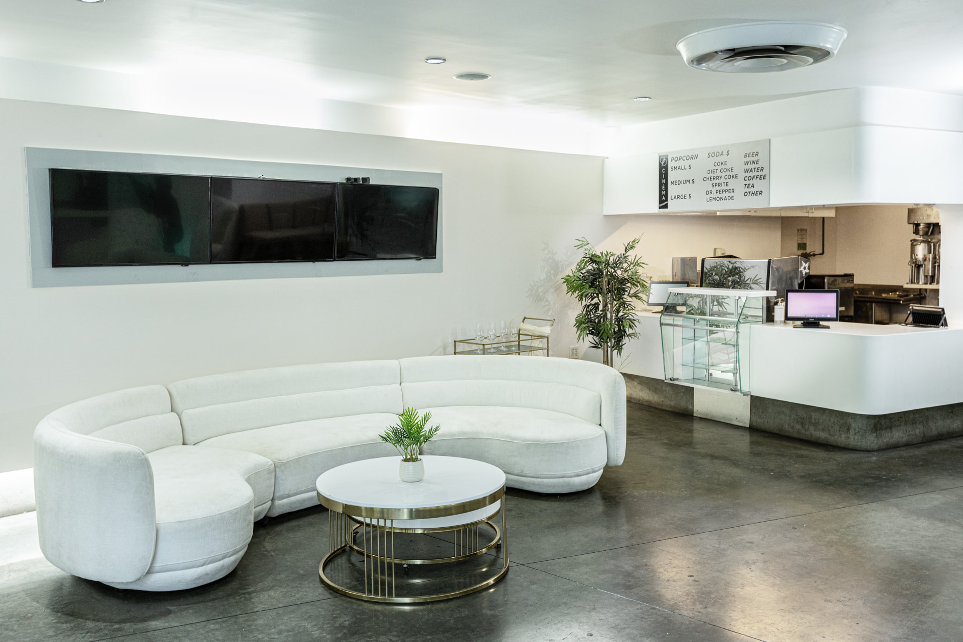 The curved white sofa facing the concessions counter in the lobby