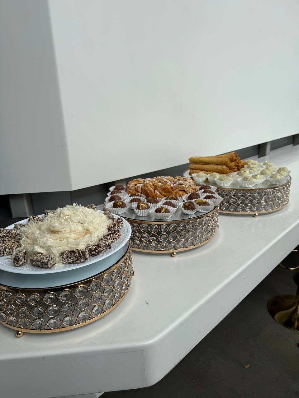 Three crystal dessert stands lined along the white lobby bar