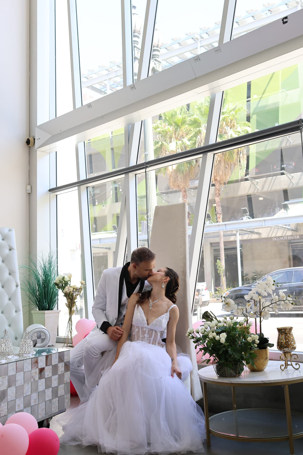 A couple kissing in the sunlit glass atrium