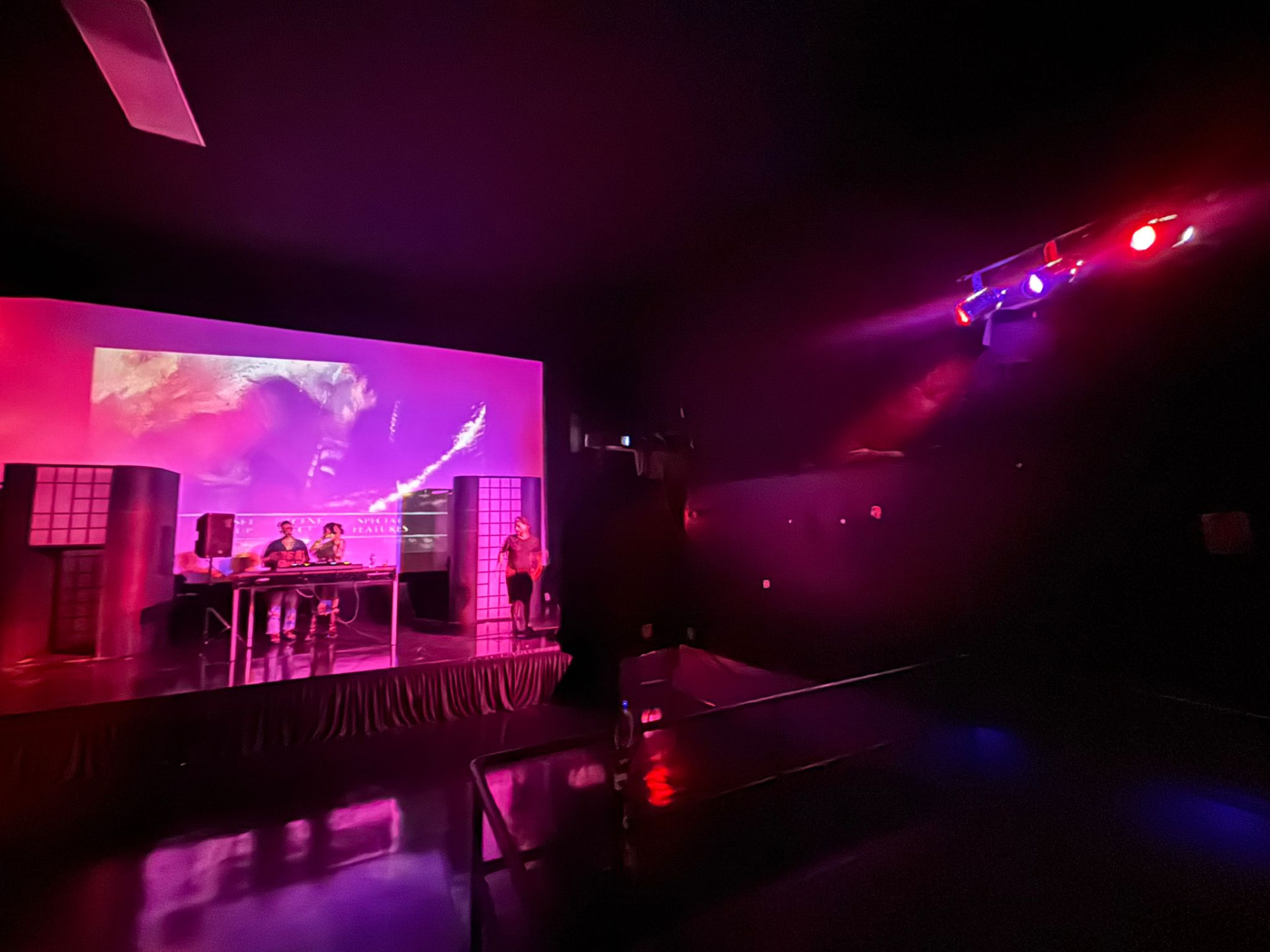 The theater stage in magenta light during a DJ set