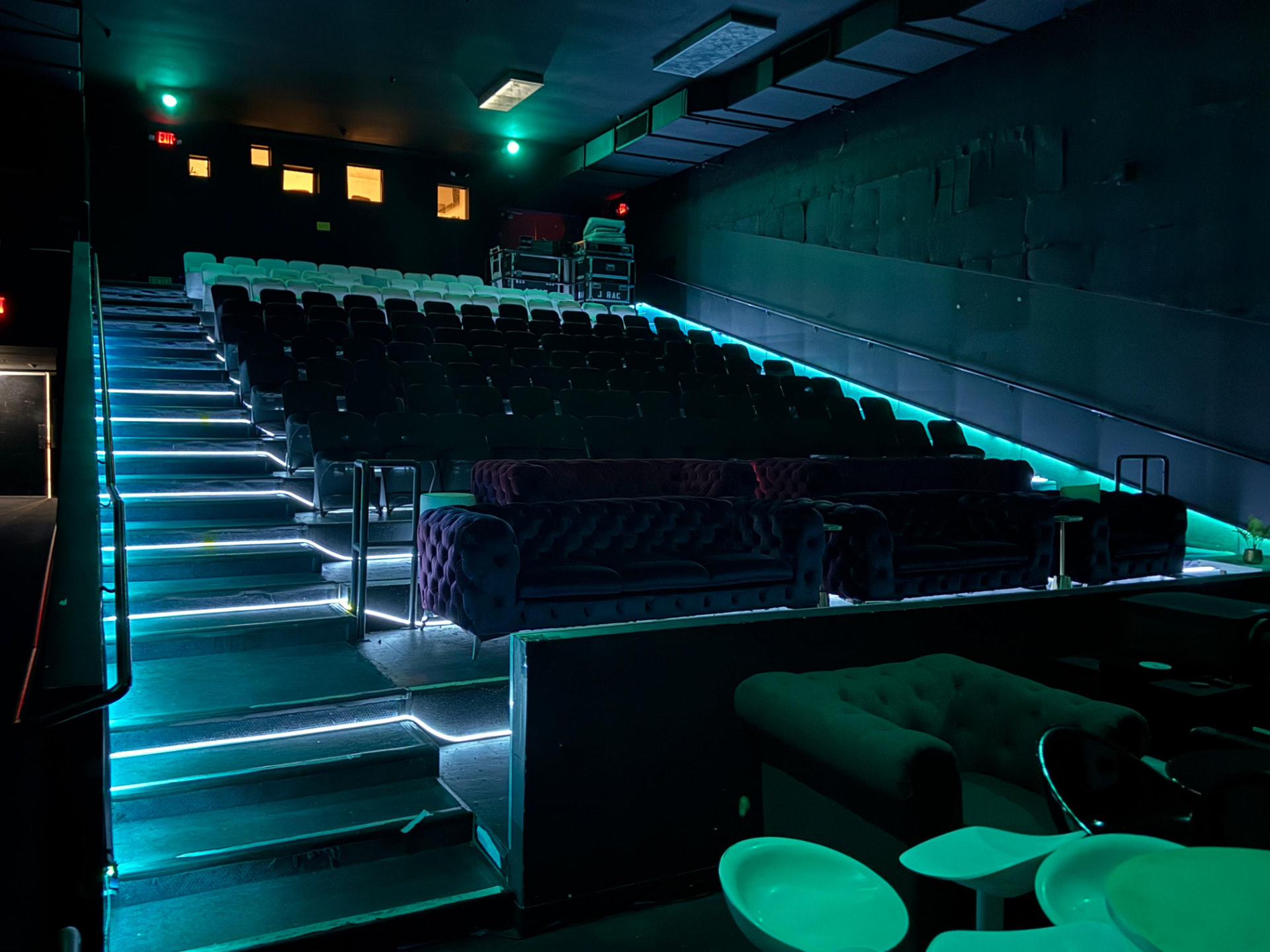Theater house with velvet sofas and teal LED stair lighting