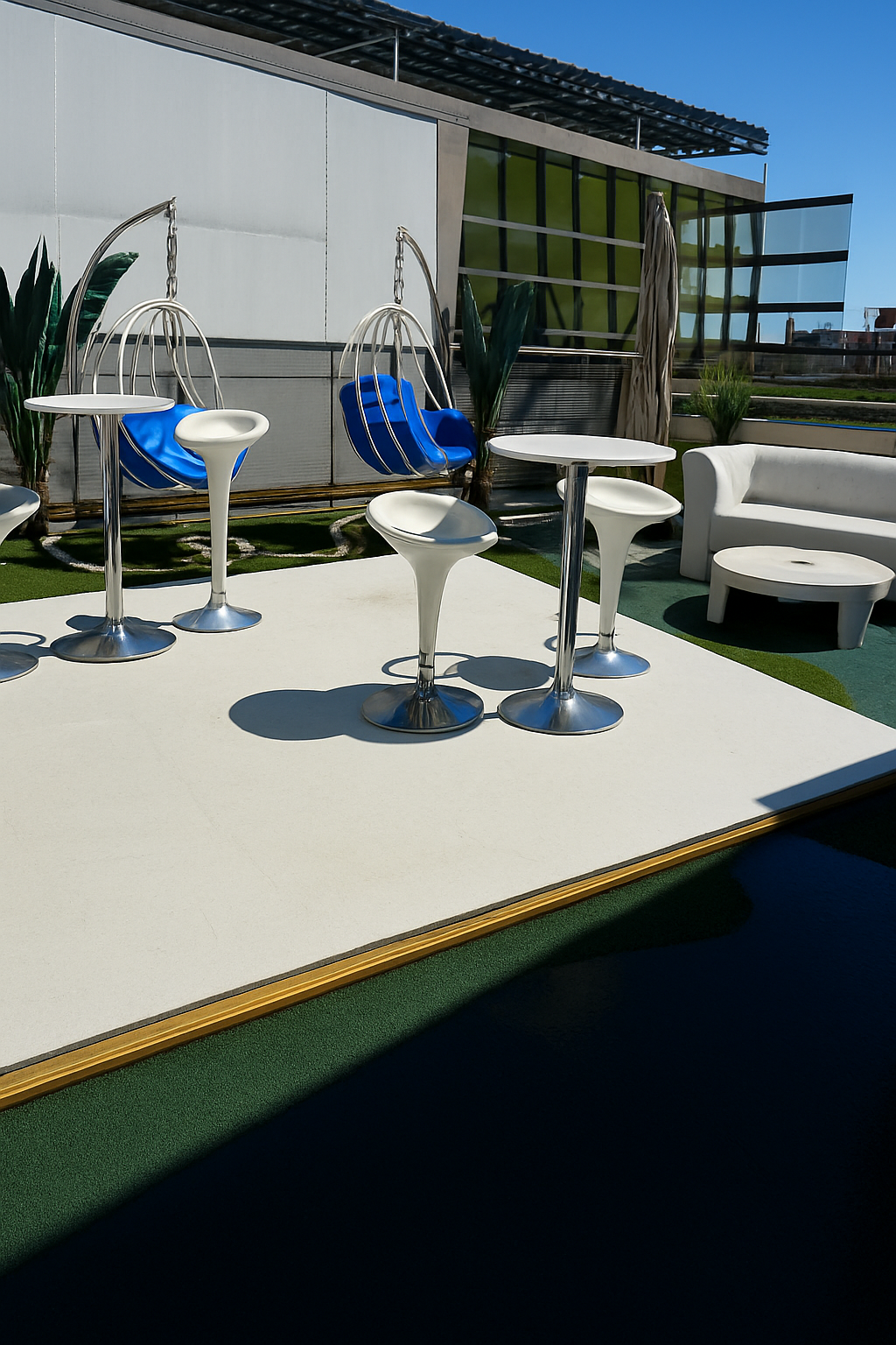 The rooftop dance floor with cocktail tables and blue swing chairs
