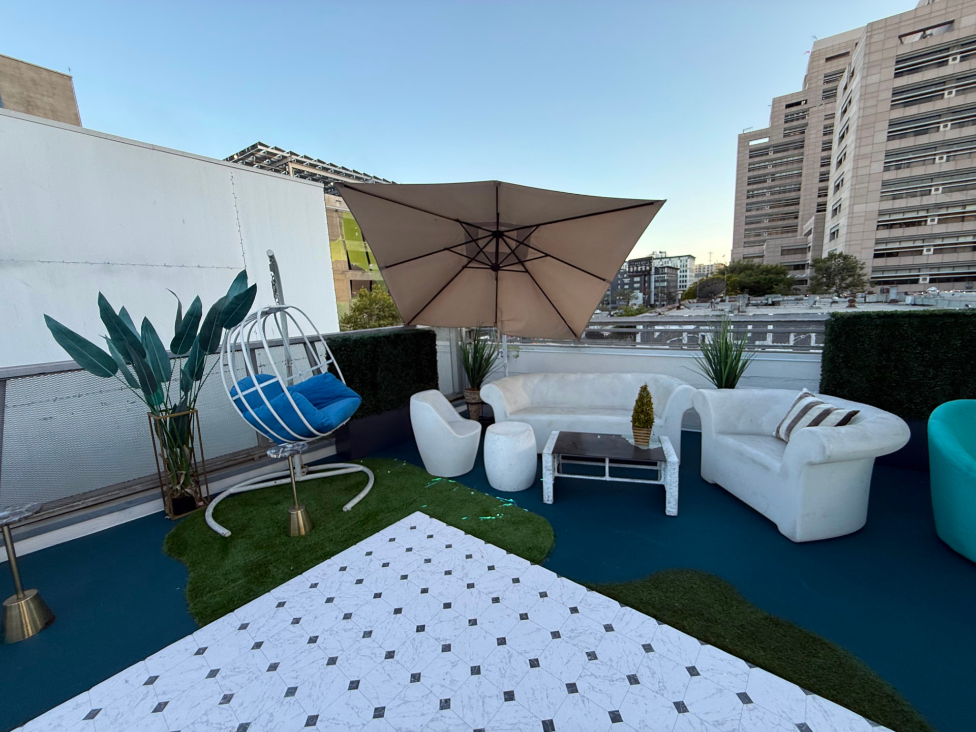 Rooftop lounge seating beneath a shade umbrella in daylight