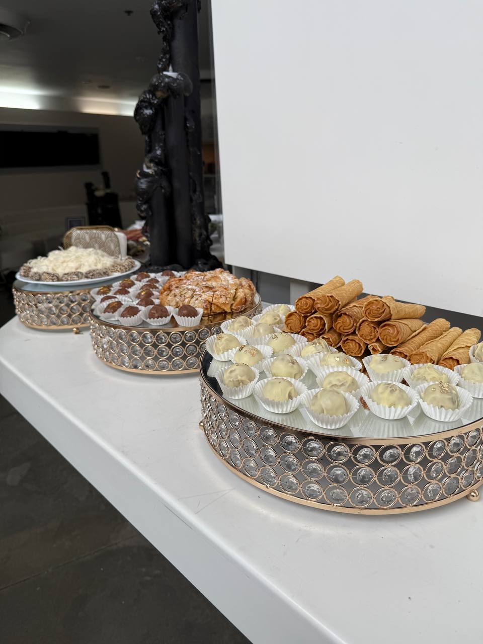 Truffles, cannoli and pastries on mirrored crystal stands